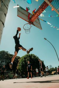 Dynamic street basketball game with young players in Brasília under clear skies.